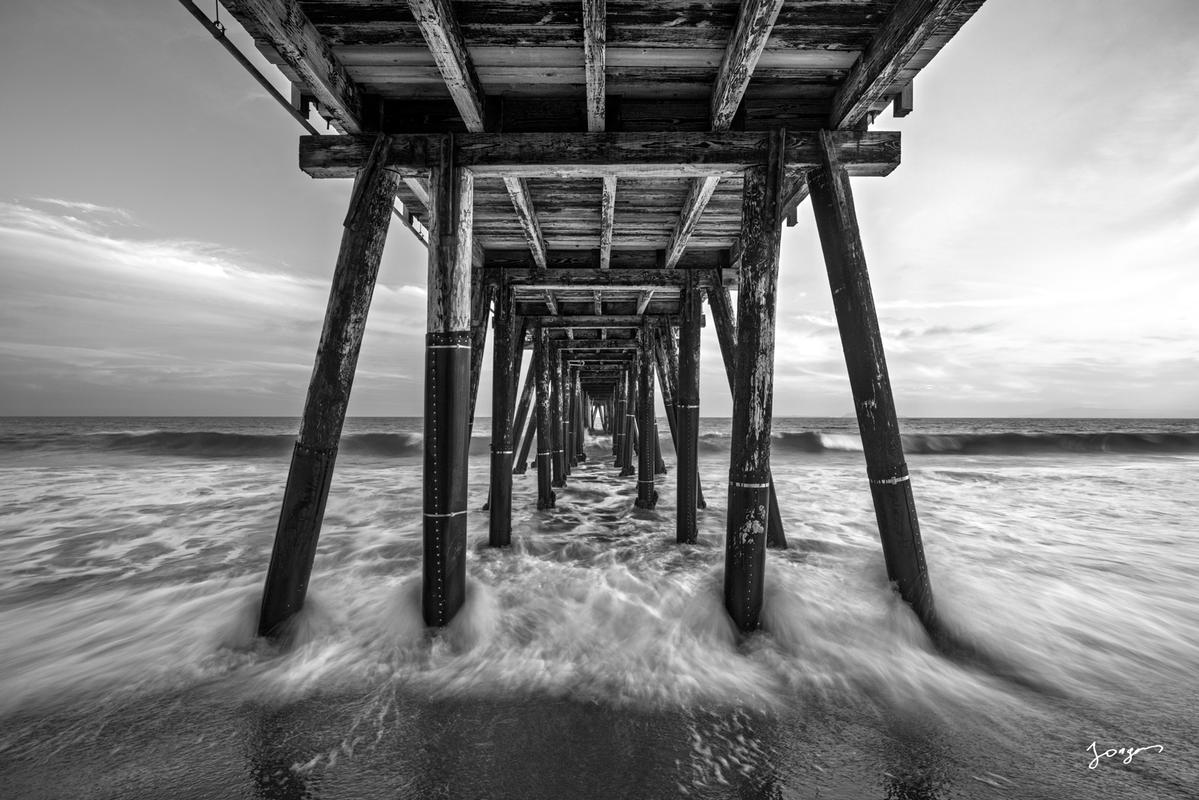 wooden pier by the pacific ocean as black and white art print by Eddie Jongas