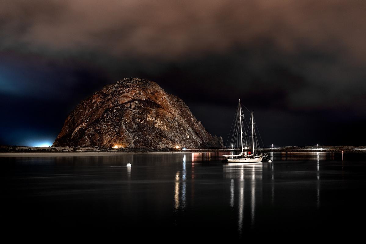 Morro rock at night with boat in foreground famous photos